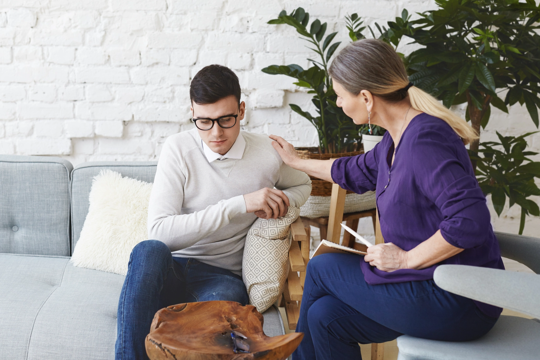 Man receiving comfort from woman therapist